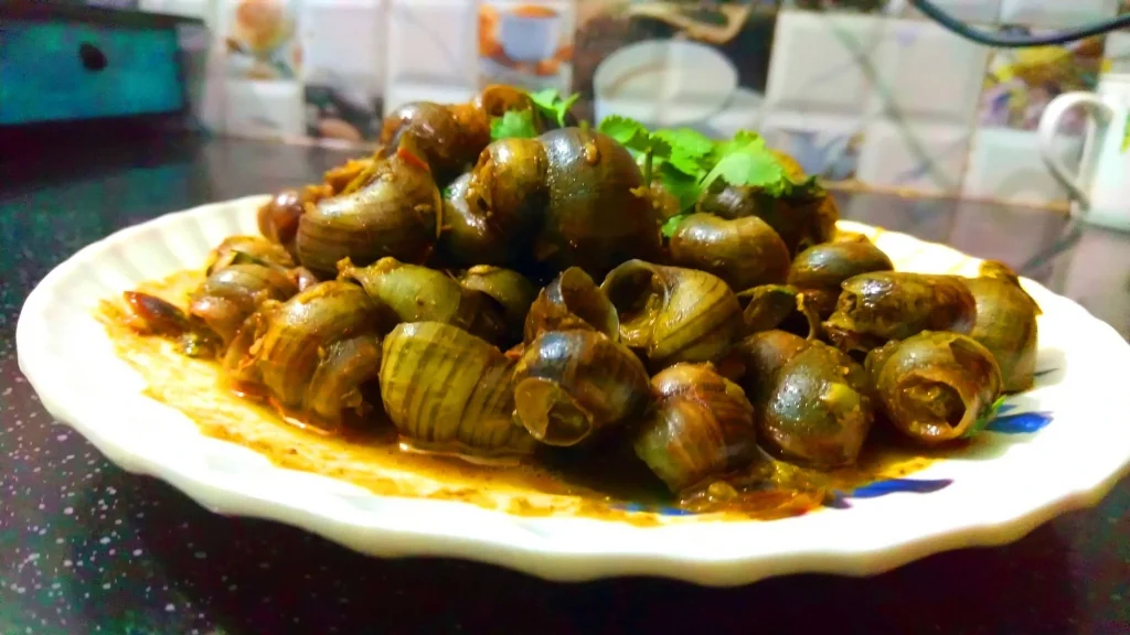 A bowl of Ghongi, traditional Tharu freshwater snail curry, served with rice in the Terai region of Nepal