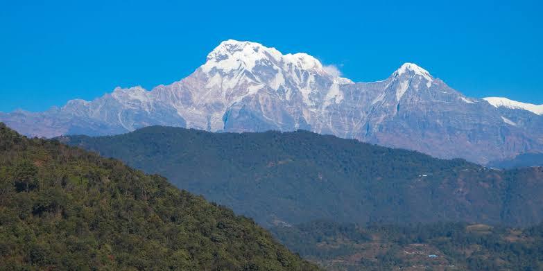 Terraced farmland and forest in Kaski district with the Annapurna range visible behind