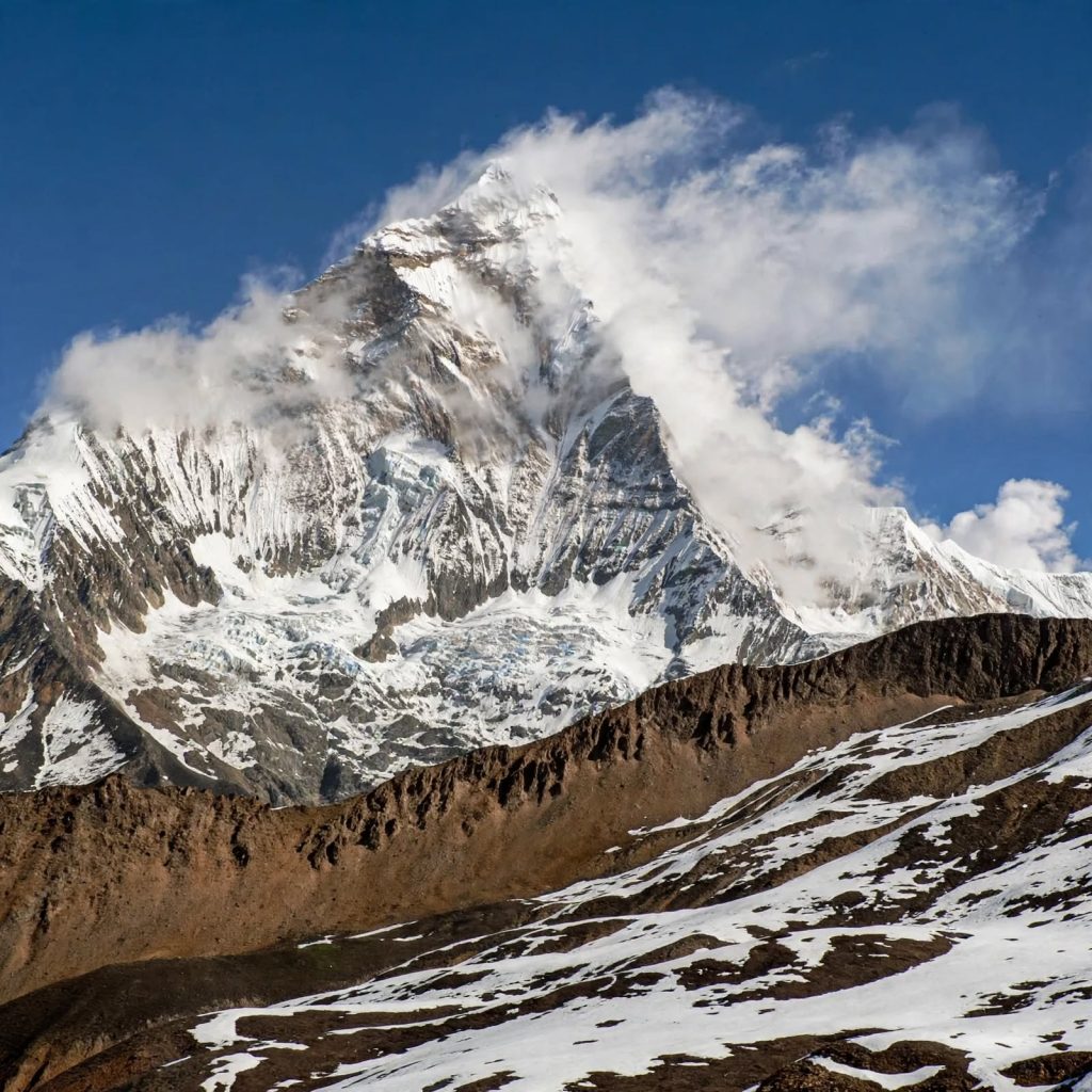 High alpine terrain above 4,000 meters in Upper Dolpo with bare rock ridges and scattered snow