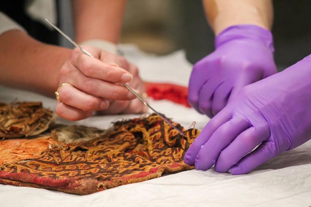 Fragment of ancient patterned textile laid out for laboratory analysis