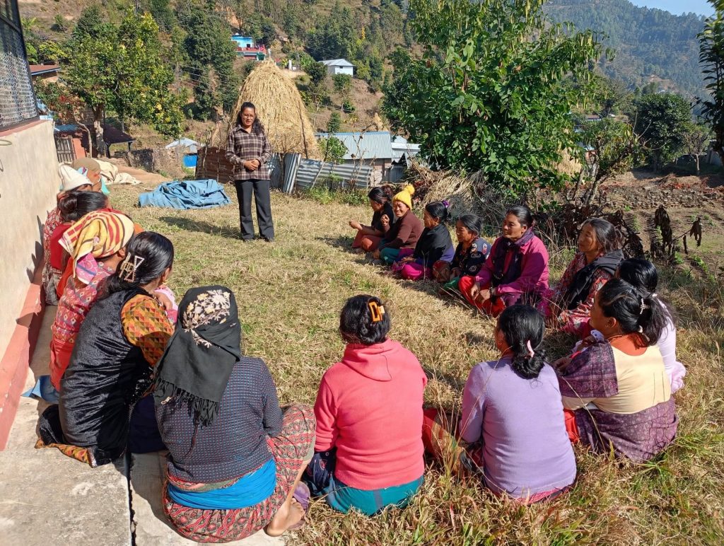 Nepali social worker meeting with a family in a village courtyard